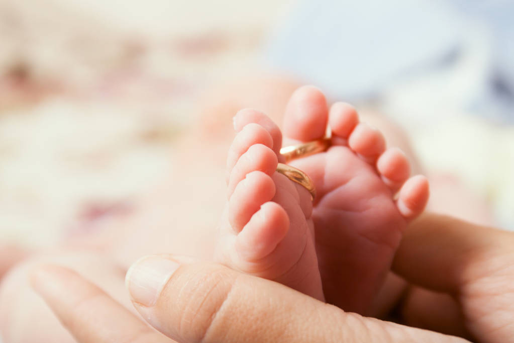 stock photo legs of an infant with wedding rings